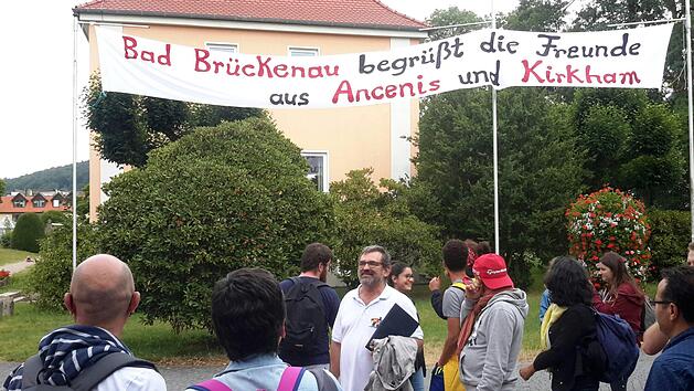 Weithin sichtbar wies ein Banner auf das Partnerschaftstreffen am Wochenende in Bad Brückenau hin. Über einen derart herzlichen Empfang freute sich auch der Leiter der französischen Delegation, Christian Prévot (Bildmitte).Foto: Rolf Pralle