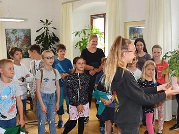 Die Kinder der gemeinsamen Ferienbetreuung des Landratsamtes Ha&szlig;berge und des Amtsgerichtes Ha&szlig;furt besuchten am Donnerstagvormittag Landrat Wilhelm Schneider in seinem B&uuml;ro und stellten allerlei interessante Fragen. Au&szlig;erdem schenkten die Buben und M&auml;dchen dem Landrat eine Tomatenpflanze. Foto: Moni G&ouml;hr/ Landratsamt Ha&szlig;berge