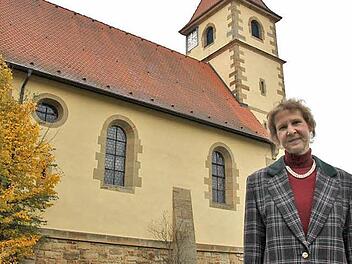 Lucia Langer vor der evangelischen Kirche in Schwürbitz, aufgenommen vom Pfarrgarten aus. Die Pfarrerin wird im November eine neue Stelle in Unterfranken antreten. Foto: Ramona Popp
