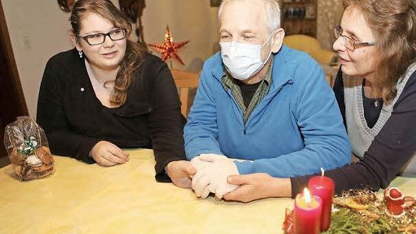 Günter Münz greift nach den Händen von Tochter Katharina (links) und Ehefrau Heidi (rechts).