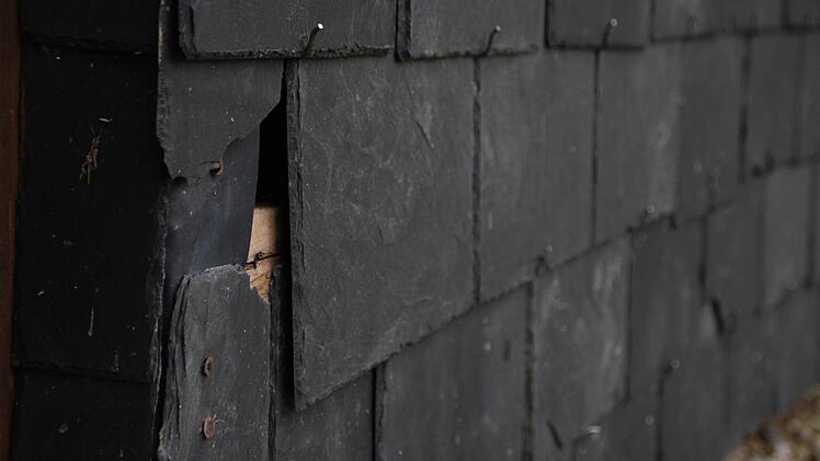 Die Fassade aus Naturschiefer weist im unteren Bereich Schäden auf. Foto: Ulrike Müller
