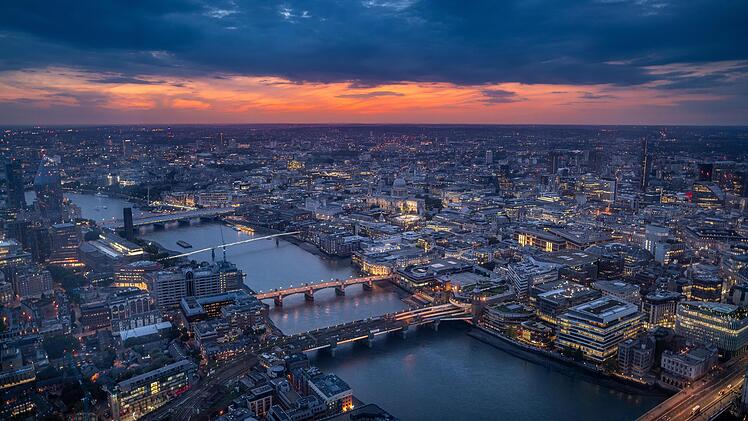 Luftaufnahme von London in der D&auml;mmerung mit Themse, Br&uuml;cken und leuchtender Skyline.