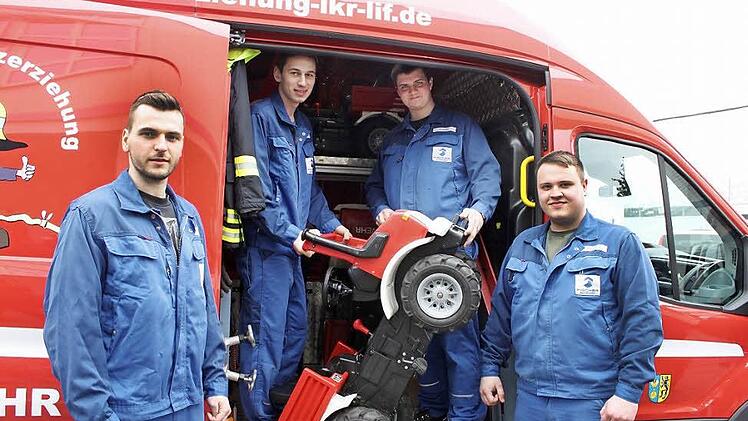 Damit der Spaß für die Kinder in der Brandschutzerziehung nicht zu kurz kommt, sind auch Tretautos mit an Bord des neuen Fahrzeuges. Junge Mitarbeiter der Maschinenfabrik Fischer haben dafür gesorgt, dass alles sicher transportiert werden kann und mit einem Griff parat ist. Im Bild von links Lothar Dill, Tobias Zollnhofer, Florian Zapf und Sebastian Knauer. Die weiteren vier Mitwirkenden hatten an diesem Tag Berufsschule. Foto: Popp