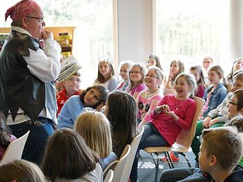 Bei "Au Kacke" müssen die Drittklässler laut loslachen. Nicht nur wegen des Ausdrucks, sondern vielmehr weil Stephan Bach das Abenteuer von Philipp und Anne so echt und lebendig vorliest.  Foto: Sarah Dann