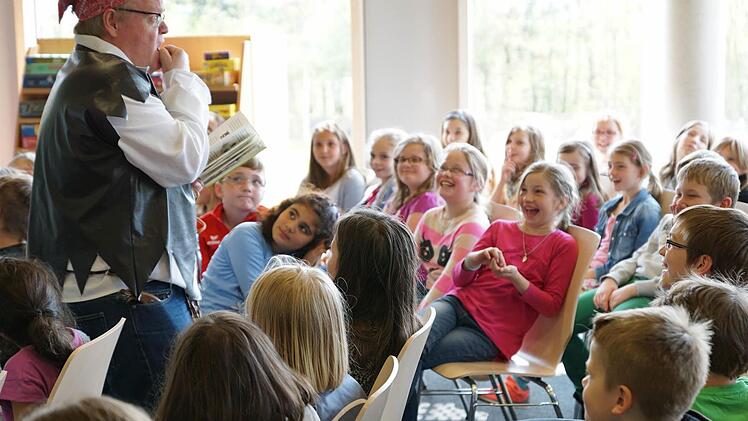 Bei "Au Kacke" müssen die Drittklässler laut loslachen. Nicht nur wegen des Ausdrucks, sondern vielmehr weil Stephan Bach das Abenteuer von Philipp und Anne so echt und lebendig vorliest.  Foto: Sarah Dann