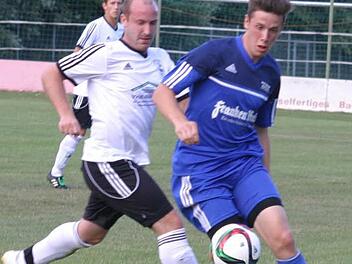 Der Eberner Rückkehrer Mittelfeldspieler Peter Kollmer (weißes Trikot ) im Zweikampf mit dem Gästespieler Lukas Riedel.