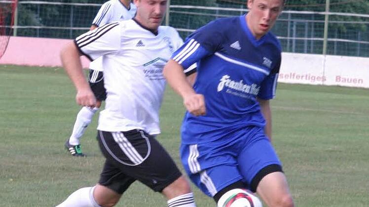 Der Eberner Rückkehrer Mittelfeldspieler Peter Kollmer (weißes Trikot ) im Zweikampf mit dem Gästespieler Lukas Riedel.