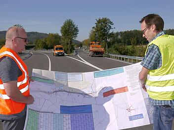 Läuft nach Plan: Wolfgang Müller (links) und Roland Daum sind nach dem Blick auf den Bauzeitplan zufrieden: der Ausbau der Bundesstraße 4 ist termingerecht fertig geworden, am Montag kann deshalb die Zufahrt von Haarbrücken nach Coburg wieder für den Verkehr freigegeben werden. Foto: Berthold Köhler