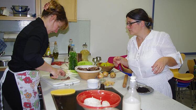Nadine Angerer schneidet Reh für die Füllung der Wildpastete, Tina Vadász-Hain gibt ihr Tipps. Foto: Heike Schülein