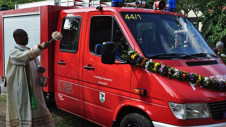 Kaplan Ferdinand Mba segnete nach dem Gottesdienst das neuen Tragkraftspritzenfahrzeug der Feuerwehr Rabelsdorf. Foto: Simon Albrecht