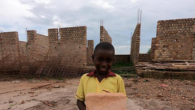 Das Foto wurde als Dankesch&ouml;n f&uuml;r die Teilnehmer an der Spendenkampagne im Sommer aufgenommen und zeigt einen der Sch&uuml;ler vor der Baustelle in Kakindu.