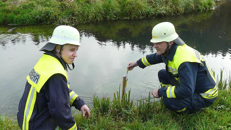Hans Illgner und Daniel Borchert messen den Pegelstand in der Aufseß in Wüstenstein. Foto: hl