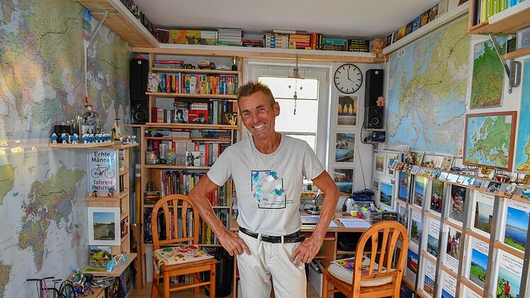 Weltkarten, Mitbringsel von seinen Radtouren und jede Menge Schl&uuml;mpfe zieren J&uuml;rgen P&ouml;hlmanns Arbeitszimmer. Hier plant er seine Touren.  Foto: Ronald Rinklef