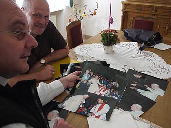 Dekan Kemmer (links) und Bürgermeister Brehm blättern in Archiv. Auf zahlreichen Fotos ist Papst Johannes Paul II. zu sehen. Foto: Lp