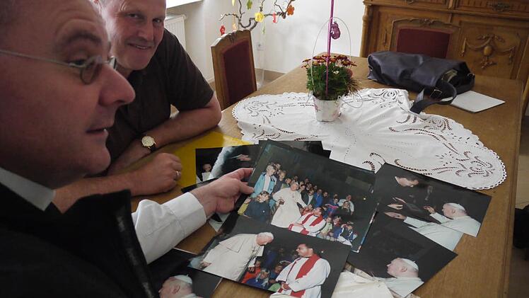 Dekan Kemmer (links) und Bürgermeister Brehm blättern in Archiv. Auf zahlreichen Fotos ist Papst Johannes Paul II. zu sehen. Foto: Lp