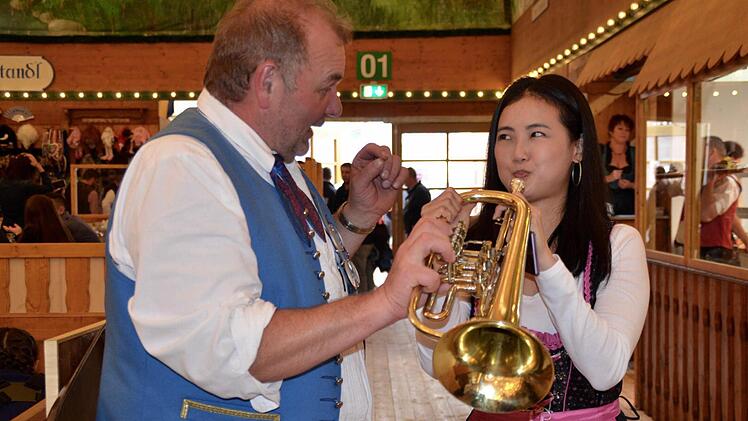 Konrad Straub erklärt einer asiatischen Besucherin, wie man die Trompete spielt.  Foto: Kathrin Kupka-Hahn