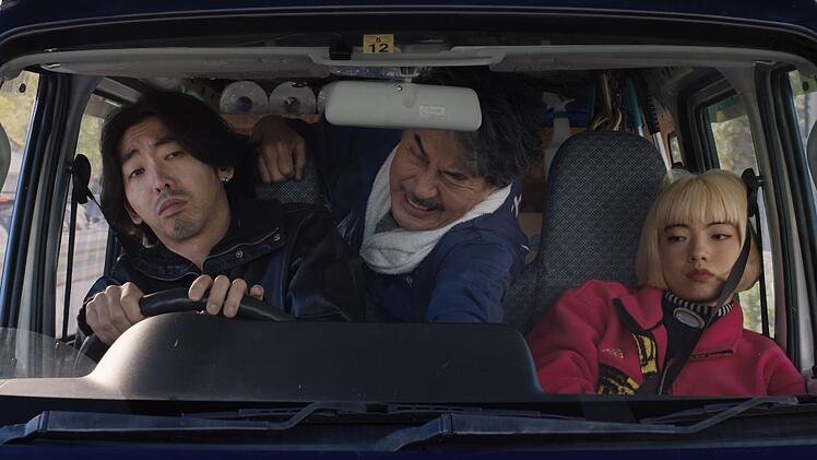 Takashi (Tokio Emoti, links), Hirayama (K&ocirc;ji Yakusho) und Aya (Aoi Yamada) quetschen sich ins Mini-Auto.