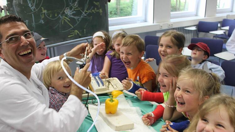 Im Inneren einer Paprika: Dr. Matthias Blanke, leitender Oberarzt an der Unfallchirurgie der Uni-Klinik Erlangen, zeigt den Besuchern des St.-Mauritius-Kindergartens in  Röttenbach, welche spannenden Dinge man mit einem Endoskop entdecken kann. Fotos: bau