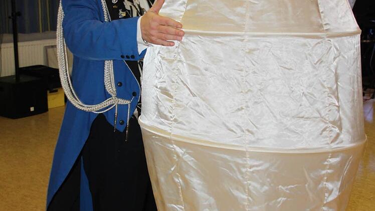 Was wohl in dem Ei steckt? Zeremonienmeister Werner Friedlein "brütet" das Überraschungsei aus. Foto: Stephan Stöckel