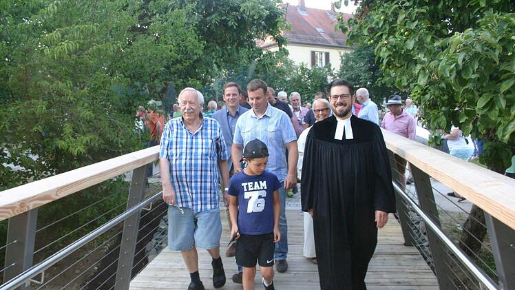 Nach der offiziellen Freigabe schritten Gerd Helbig (Schwei&szlig;- und Holzarbeiten), B&uuml;rgermeister Tobias Ehrlicher,  Timo Machold (Konstruktion), Gemeindereferentin Birgit M&uuml;ller und Pfarrer Christian Rosenzweig (von links) &uuml;ber die neue Wallgrabenbr&uuml;cke. Foto: Martin Rebhan