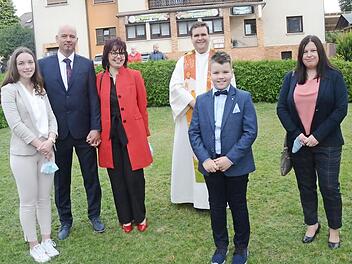 Erstkommunikant Hannes Kirchner mit Pfarrer Detlef Pötzl sowie seinen Familienangehörigen