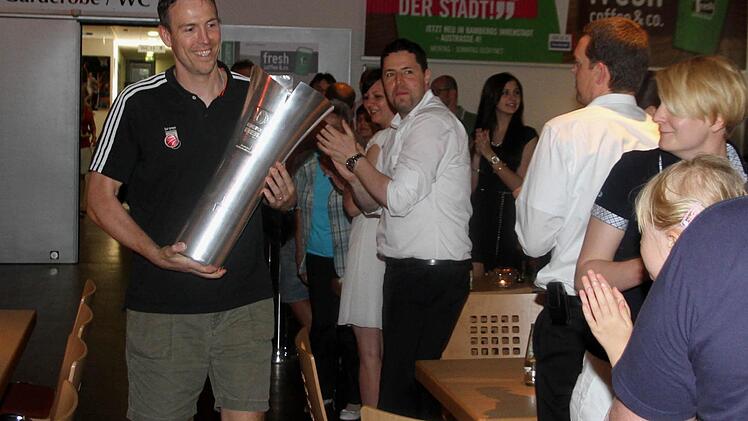 Headcoach Chris Fleming trägt stolz den "Meister-Pott" in die Oddset Lounge.