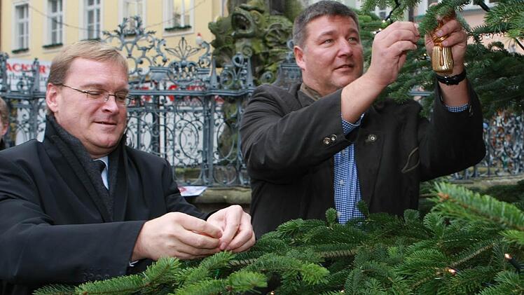 OB Andreas Starke (links) und Klaus Stieringer von Stadtmarketing  beim Schmücken des Baumes der Hoffnung am Gabelmann.  Foto: Harald Rieger (Archiv)