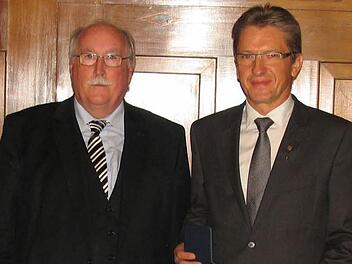 Hans Rebhan (rechts) erhielt aus den Händen von Wilhelm Wenning die Auszeichnung. Fotos: Regierung von Oberfranken