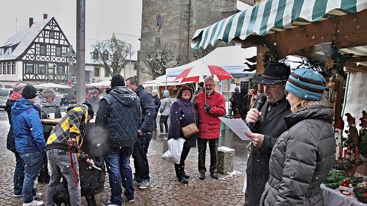 Christina Seebach-Künzel und Bürgermeister Jürgen Hennemann (von rechts) eröffneten bei Schneefall und ungemütlich nasskaltem Wetter den Weihnachtsmarkt. Dicht umringt waren meist wärmende Öfen, wie im Foto links.Helmut Will