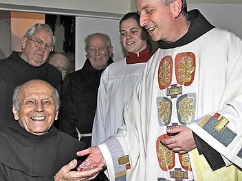 Franziskanerpater Maximilian Wagner (rechts) überreicht Bruder Salvator im Kloster Altstadt einen symbolischen Diamanten zum Ordensjubiläum. Foto: Gerd Schaar