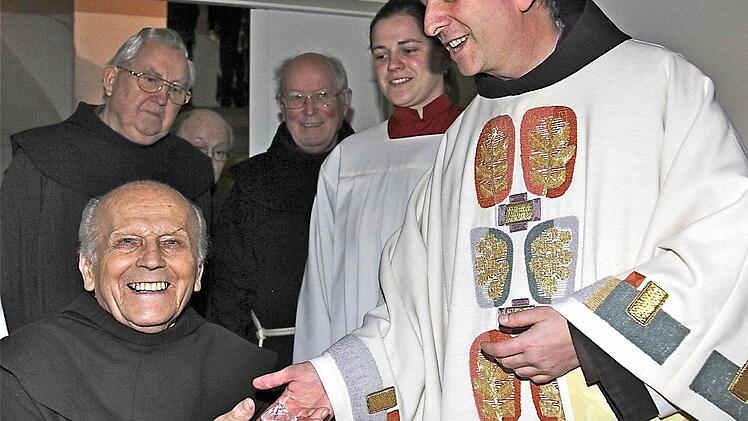Franziskanerpater Maximilian Wagner (rechts) überreicht Bruder Salvator im Kloster Altstadt einen symbolischen Diamanten zum Ordensjubiläum. Foto: Gerd Schaar