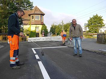 Letzter Feinschliff: Gerhard Reh (rechts) und sein Bauhof-Kollege Sven Henzel haben mit der Fahrbahnmarkierung die Deckensanierung in der Bahnhofstraße abgeschlossen. Jetzt ist die Straße wieder für den Verkehr frei.Foto: Berthold Köhler