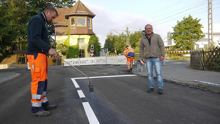 Letzter Feinschliff: Gerhard Reh (rechts) und sein Bauhof-Kollege Sven Henzel haben mit der Fahrbahnmarkierung die Deckensanierung in der Bahnhofstraße abgeschlossen. Jetzt ist die Straße wieder für den Verkehr frei.Foto: Berthold Köhler