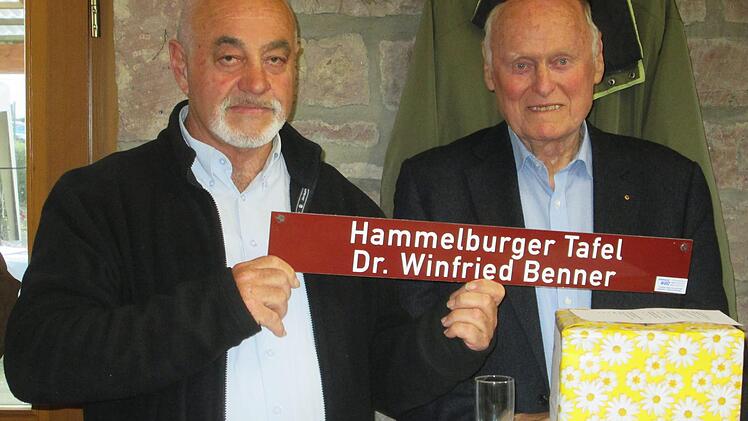 Ein Ehrenschild, das Vorsitzender Dieter Roth an Winfried Benner überreichte, soll an den Gründer der Hammelburger Tafel erinnern. Foto: Winfried Ehling