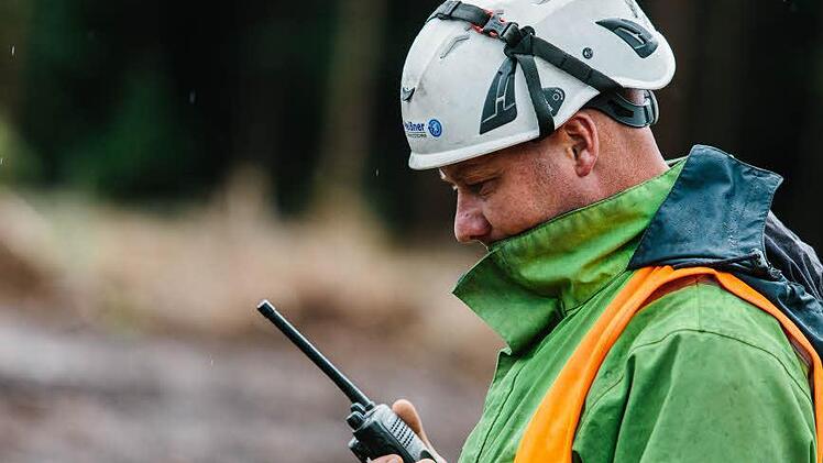 Michael Gang steht mit dem Arbeiter auf dem Mast in Funkkontakt.