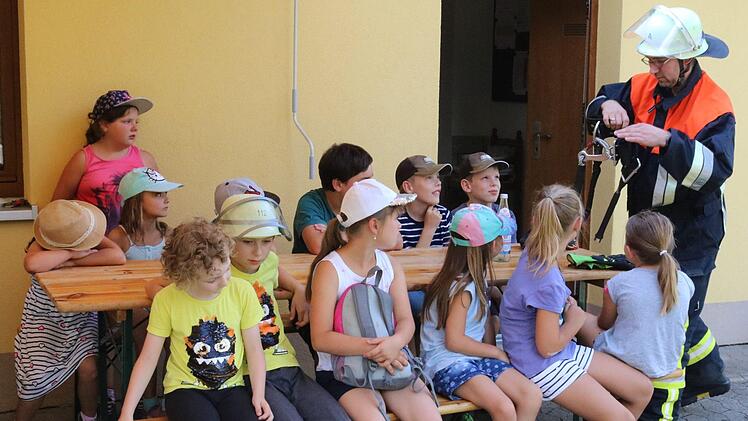 Löschgruppenführer Mario Holzmann erklärte den Kindern, was alles zur Schutzausrüstung eines Feuerwehrmannes gehört. Foto: Janina Reuter-Schad