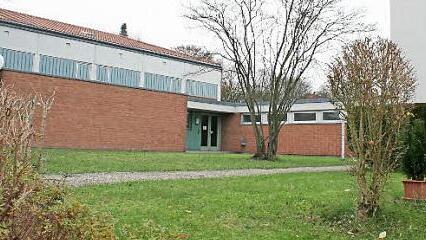 Die Schule (rechts) und die Turnhalle (links) sind durch einen Zwischenbau verbunden. Auch der Fußweg soll neu verlegt werden.  Fotos: Evi Seeger