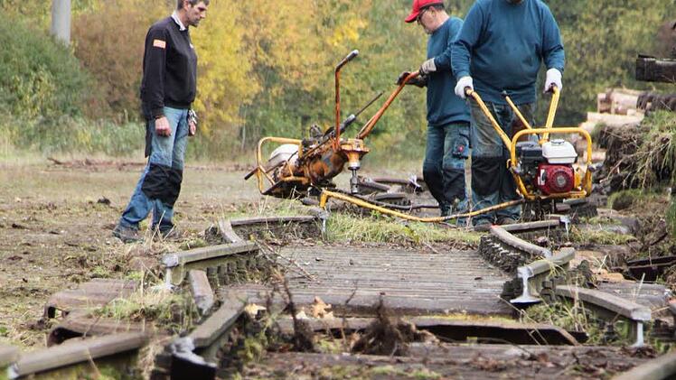 Mit einer Gleisschraubmaschine lösen die Arbeiter die Schrauben, mit denen Schienen und Schwellen zusammengehalten werden. Foto: Ulrike Müller