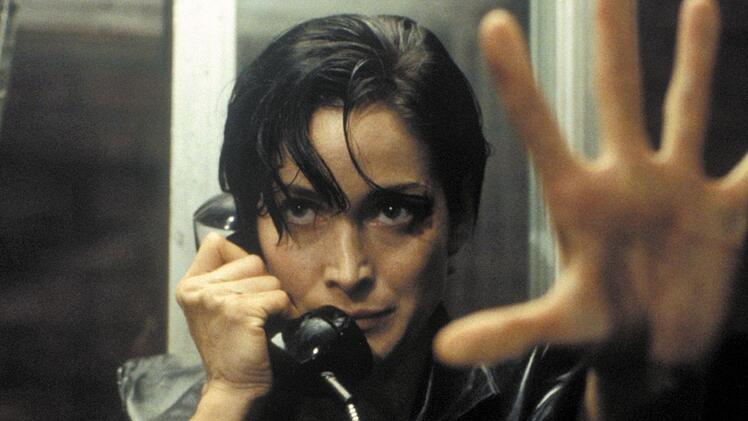 Trinity (Carrie-Anne Moss) nimmt den Ausgang aus der Matrix: eine &ouml;ffentliche Telefonzelle.