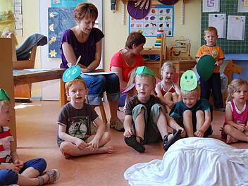Die Kinder des Hassenbacher Kindergartens bei ihrem Singspiel vor ihnen auf dem Boden das Ei, das zum Schmetterling wird.  Fotos: Günther Straub