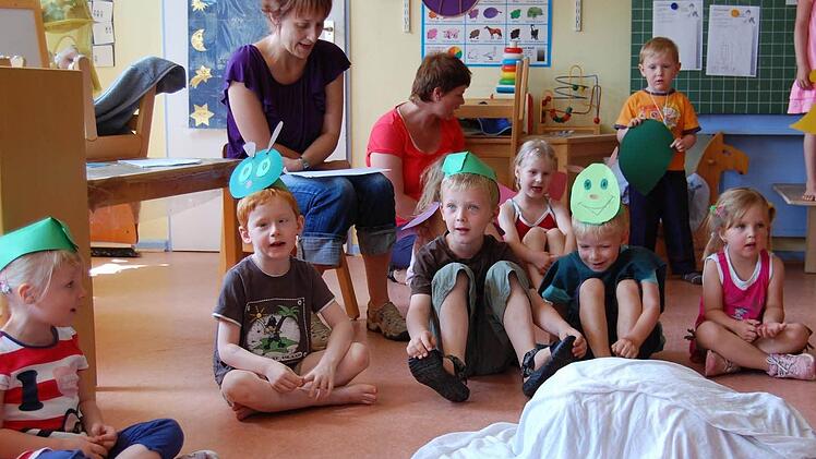 Die Kinder des Hassenbacher Kindergartens bei ihrem Singspiel vor ihnen auf dem Boden das Ei, das zum Schmetterling wird.  Fotos: Günther Straub