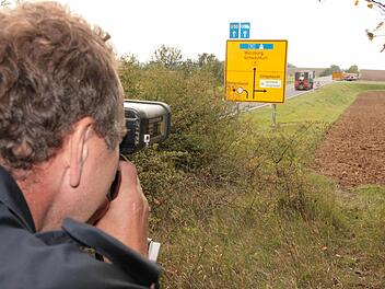 Lothar Manger von der Polizei Bad Kissingen misst mit einer Laserpistole an der ehemaligen B19 in Richtung der Rottershäuser-Kreuzung. Fotos: Paul Ziegler/ Archiv