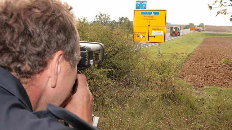 Lothar Manger von der Polizei Bad Kissingen misst mit einer Laserpistole an der ehemaligen B19 in Richtung der Rottershäuser-Kreuzung. Fotos: Paul Ziegler/ Archiv