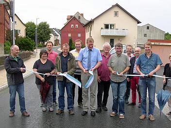 Gemeinsam vollzogen Bürgermeister Michael Keilich (CSU), Gemeinderäte, Bauamtsleiter Stefan Dümmlein, bauleitender Ingenieur Klaus Müller (IVS Kronach ) sowie Jürgen und Christian Carl (Franz Hofmann Bau Sonnefeld) als Repräsentanten der am langwierigen Ausbau beteiligten Baufirma den obligatorischen Bandschnitt. Foto: Klaus Oelzner
