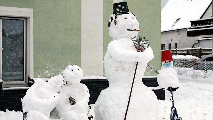 Ein großer Schneemann steht direkt am Ködelberg (Bild rechts), und in Nurn baute Anna Deuerling an der Hauptdurchfahrtsstraße gleich eine ganze Schneemann-Familie auf (Bild links). Fotos: Michael Wunder