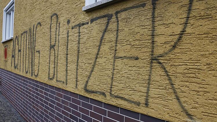 Sieben Meter lang und einen Meter hoch ist der Schriftzug "Achtung Blitzer" auf einem Wohnhaus in Bug. Auch ein Messgerät wurde dazu gemalt. Foto: Matthias Hoch