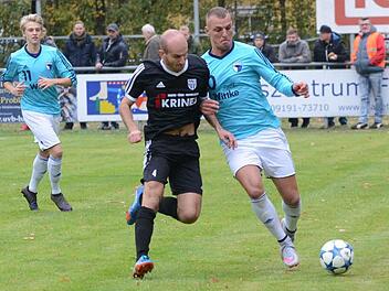 Der Sander Florian Gundelsheimer (dunkles Trikot), Schütze des 0:1, im Zweikampf mit seinem Gegenspieler Genc Bajrami. Im Hintergrund der Forchheimer Henrik Hassa.