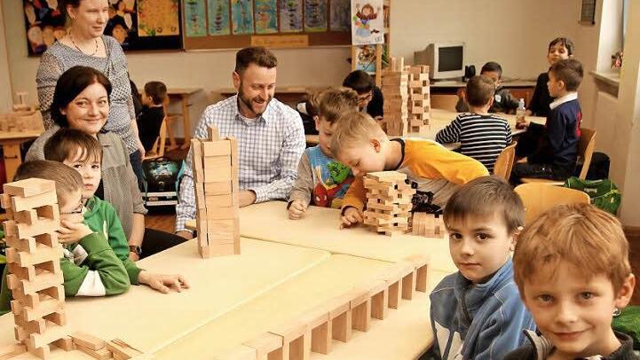 Schon nach kurzer Zeit hatten die Schüler die ersten Bauwerke mit den Holzklötzchen erstellt; die Lehrerinnen Jutta Aumüller und Christine Heger sowie Stadtrat Joachim Stark (von links) freuten sich über den ersten Erfolg mit dem kreativen Spielmaterial. Foto: Günther Geiling
