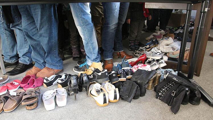 Bückware unterm Tisch: das Angebot an liegengebliebenen und gefundenen Schuhen. Foto: Simone Bastian