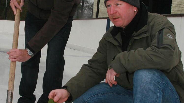Die Eismeister Reiner Foltes und Gerald Leppert stechen mit einem Spaten die Blättenr einzeln aus dem Eis heraus, denn sonst bekommt das Eis "Windpocken".